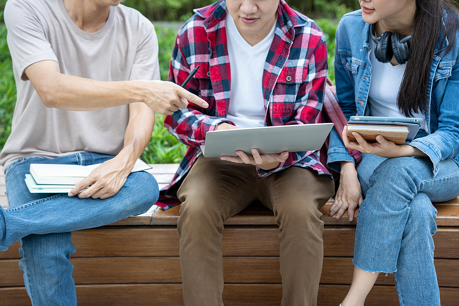 Group of chemistry students studying together from a laptop.